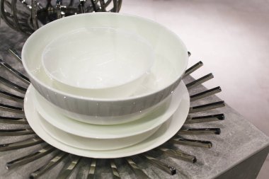 Masada boş beyaz seramik tabaklar, masada metal dekoru olan boş beyaz seramik tabaklar.