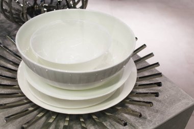 Masada boş beyaz seramik tabaklar, masada metal dekoru olan boş beyaz seramik tabaklar.