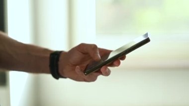 Erkek eller telefonda yazı yazıyorlar. Yüksek kaliteli FullHD görüntüler. Solak adam.