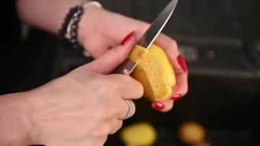 Lavaboya bıçakla patates soyan kadın. Yüksek kaliteli FullHD görüntüler