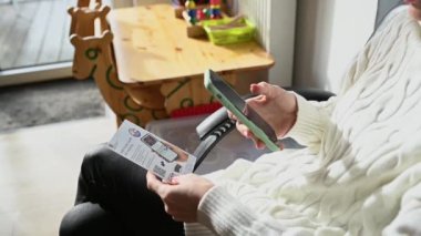 Hastanenin bekleme odasında bekleyen ve QR kodunu telefonla tarayan bir kadın. Yüksek kaliteli FullHD görüntüler