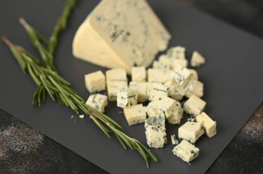 Gri bir tahtada mavi bir peynir ve biberiyeyle dilimler. Yüksek kalite fotoğraf