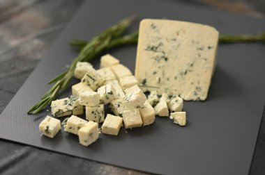 Gri bir tahtada mavi bir peynir ve biberiyeyle dilimler. Yüksek kalite fotoğraf