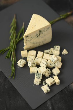 Gri bir tahtada mavi bir peynir ve biberiyeyle dilimler. Yüksek kalite fotoğraf