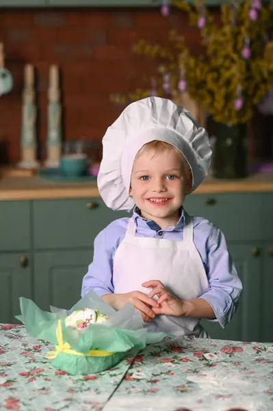 Little cute boy in a chef hat with eastern cake. High quality photo