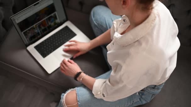 一个戴眼镜的金发女人坐在沙发上 带着笔记本电脑在家里工作 优质Fullhd影片 — 图库视频影像