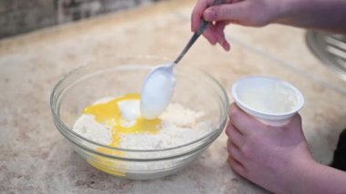 Kadın eli hamura ekşi krema ekliyor. Yüksek kaliteli FullHD görüntüler
