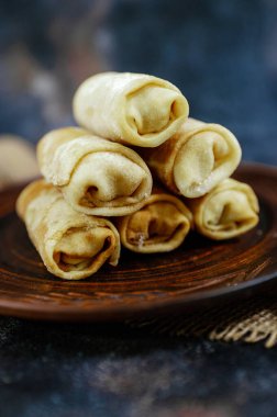 Doldurulmuş yuvarlanmış gözlemeler, düzgün bir şekilde ahşap bir tabağa istiflenmiş. Yüksek kalite fotoğraf