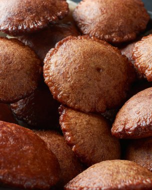 Kevum veya kavum adı verilen kızartılmış Sri Lanka tatlısının yakın plan görüntüsü, pirinç unu ve palmiye şekerinden veya kithul şekerinden yapılmış geleneksel tatlı yığını, seçici odak noktasında tam çerçeve görünümü