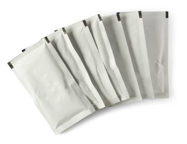 Beyaz arkaplanda izole edilmiş boş beyaz kese paketleri yığını, yiyecek veya ilaç paketleme modelleme şablonu yakın plan