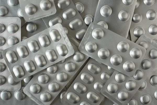 Gümüş renkli kabarcık paketleri, alerji için tıbbi ilaçlar, antibiyotik, ağrı kesiciler, tabletler için paketler, tam çerçeve arka plan