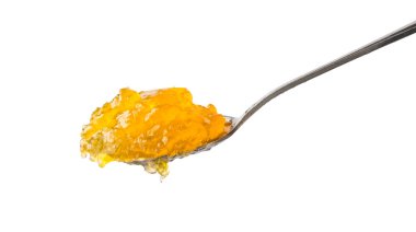 Beyaz arkaplanda izole edilmiş bir kaşık dolusu meyve reçeli, yakın plan.