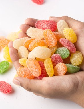 Bir avuç dolusu jüpiter, renkli şekerleme türü beyaz arka planda izole edilmiş, yumuşak odaklı