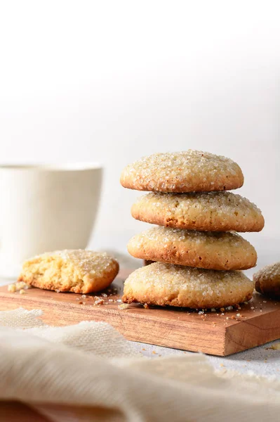 sugar cookies, consist of butter, flour and sugar, close-up of baked sweet biscuits and tea cup in the background,soft-focus with copy space