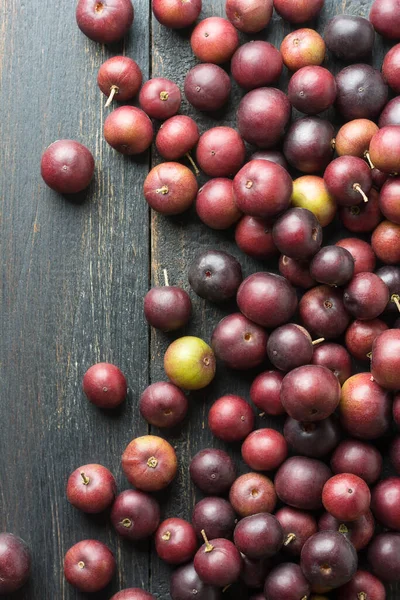 Scattered Governor Plum Fruits Black Rustic Table Top Flacourtia Indica — Stock Photo, Image