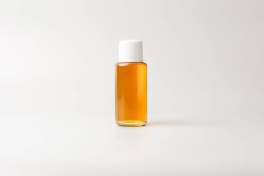 Beyaz kapaklı küçük yağ şişesi, model şablon, gri arka planda izole edilmiş.