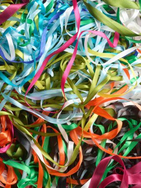 Bir demet karışık renkli tekstil saten kurdeleleri, tam çerçeve arkaplan, yukarıdan alınmış.