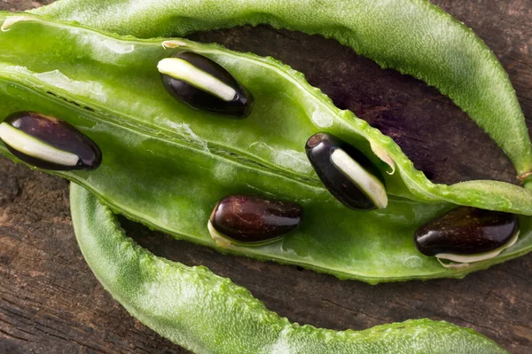 種子を持つヒヤシンス豆の鞘のクローズアップマクロビュー ラボピュロス 別名ヴォールパディ豆 木製の表面上の食用インド野菜 — ストック写真