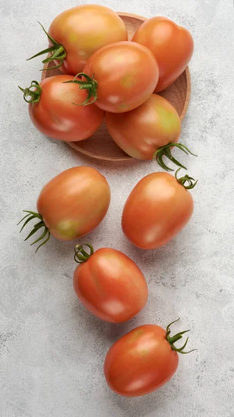 白い質感の表面に散在する木製のプレート上に熟したトマト 上から取られた食用果実 — ストック写真