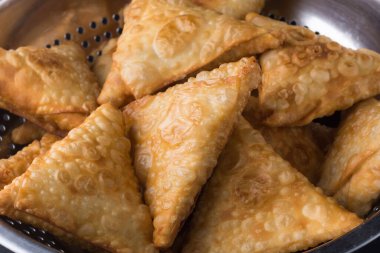 Samosa ya da samusa, bol yağda kızartılmış, baharatlı patatesle doldurulmuş üçgen şekilli hamur işi, Güney Asya 'da popüler aperatif