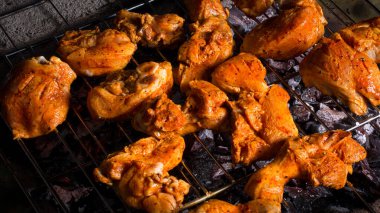 Baharatlı ya da kaplamalı tavuk parçaları ızgara ya da tütsülenmiş sıcak ızgarada ızgara et, duman ya da ızgara yakın çekim