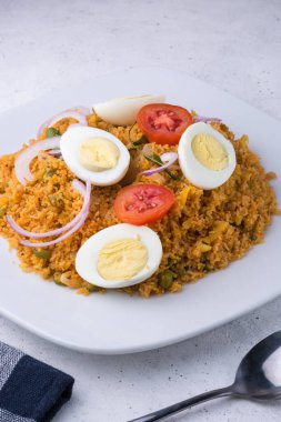Haşlanmış yumurta, domates, soğan ve köri yapraklı biryani olarak da bilinen pirinç erişte yemeği, Sri Lanka ve Güney Hindistan yemeklerine yakın görüş sunar.