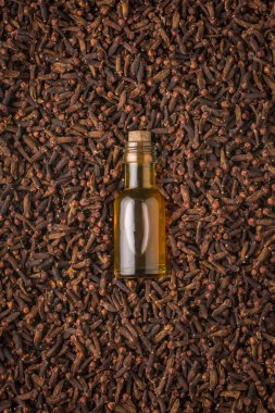 Kuru karanfilli bir şişe karanfil yağı, aromatik baharat ve gerekli yağlı bitki, üst görünüm.