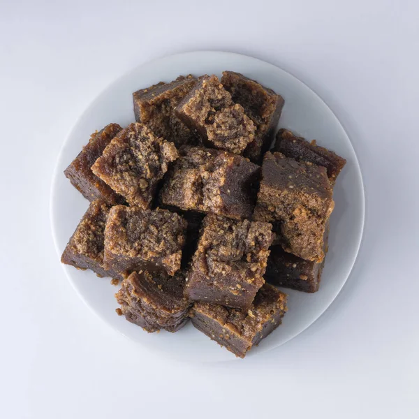 stock image plate of dodol isolated on white background, also called kalu dodol, sri lankan dark sweet candy, made from coconut milk, jaggery and rice flour, sticky, thick, sweet toffee