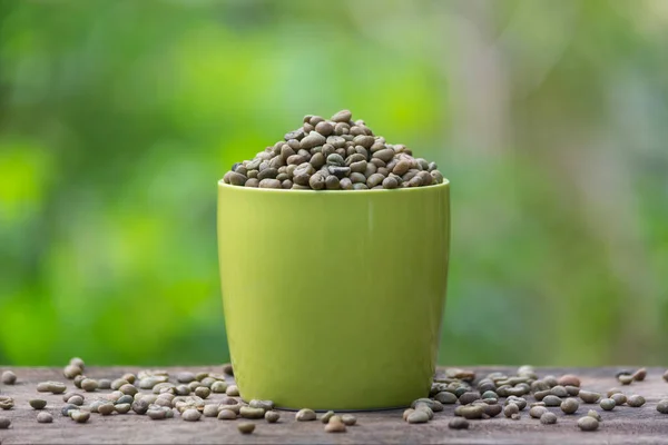 Zelené Sušené Surové Kávové Zrno Zeleném Šálku Umístěné Dřevěném Povrchu — Stock fotografie