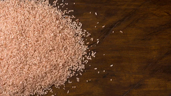 Whole Grain Brown Rice Scattered Wooden Table Top Closeup View — Stock Photo, Image