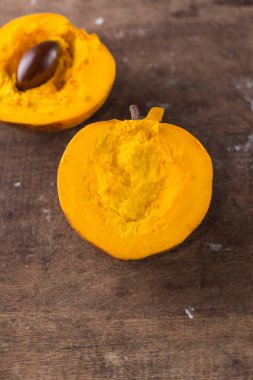 Yumurta meyvelerinin yarısı ahşap masa üstünde kesilmiş, yakın çekim tropikal meyve manzarası.