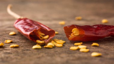 Ezilmiş kırmızı kırmızıbiber, ahşap masa yüzeyinde tohumlu kurutulmuş kırmızı biber, yakın çekim makrosu.