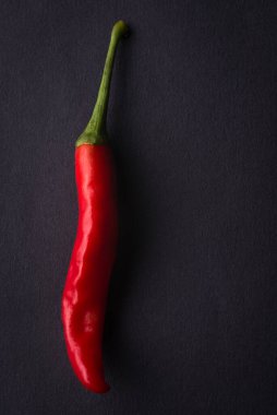 Kırmızı biber siyah desenli bir yüzeye izole edilmiş, yakın çekim makrosu.