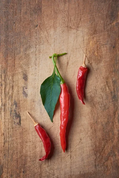 Κόκκινο Τσίλι Καυτερές Πιπεριές Καυτερές Πιπεριές Φύλλα Ξύλινο Τραπέζι Πάνω — Φωτογραφία Αρχείου