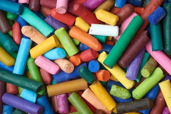 Çok renkli kullanılmış yağ pastel boya kalemi yığını. Eski kullanılan mum boya kalemlerinin yarısının yakın çekimi. Tam kare arka planda, yukarıdan alınmış.