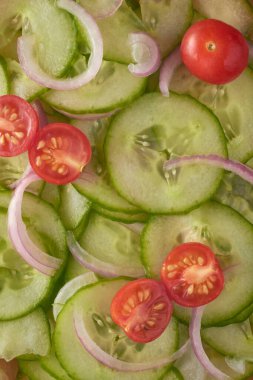 Salatalık dilimlenmiş salatalık ve soğan salatası, sade ve lezzetli vejetaryen yaz yemeği, yukarıdan ateşle ve yemek arkaplanıyla çekilmiş.