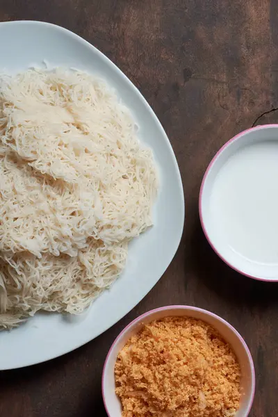 white string hoppers with coconut sambol and coconut milk, popular traditional dish served for breakfast or dinner, taken straight from above with copy space