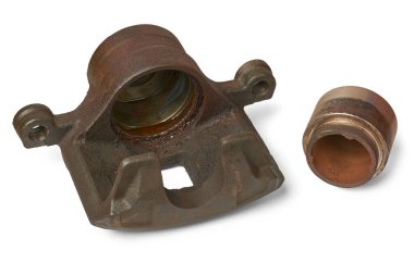 Eski disk fren ayarlayıcısı ve piston, arabanın hidrolik fren sistemindeki paslı ve yıpranmış bileşenler, frenleme sisteminin düzenli denetimi ve bakımı, beyaz arka planda izole edilmiş.