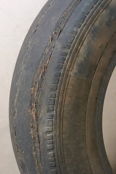 close-up of old worn out tire surface with exposed metal codes, extremely worn out condition and pose significant safety hazards, illegal and unsafe driving and vehicle maintenance concept