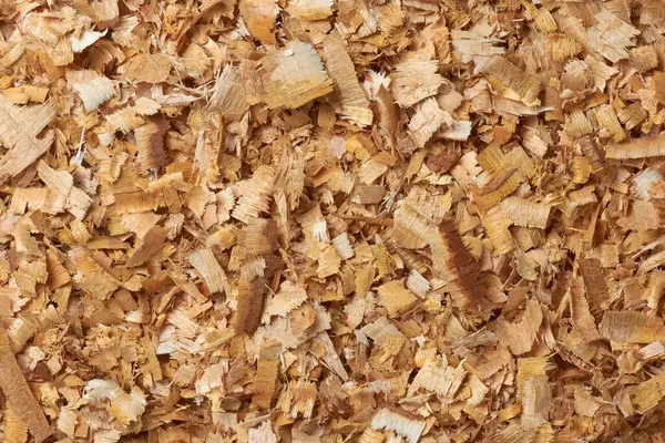 wood chips or shavings, small pieces of wood produced as a byproduct, shaved or chopped from larger pieces of wood, renewable and environmentally friendly resources, full frame background