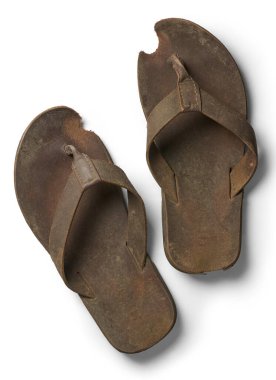 Bir çift eski kullanılmış sandalet terliği izole edilmiş beyaz arka plan, uzun süre kullanılmaktan yıpranmış ve yukarıdan alınmış soluk kayışlar.