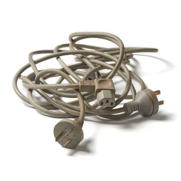 灰颜色旧的使用纠结钢丝绳与电源塞隔离白色背景 扭曲混乱的电缆在选定的焦点和阴影 免版税图库图片