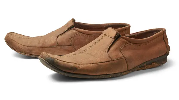 一双旧的休闲鞋 白色底色 褐色低跟软垫或鞋 侧面没有紧固件或鞋带 免版税图库照片