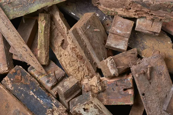 stock image pile of scrape wood pieces with nails in full frame background, left over decayed or rotten weathered wood blocks from construction, unusable for recycling taken from above