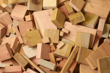 pile of wood scraps or offcuts, many shapes and sizes leftover blocks or pieces of wood from various woodworking projects, full frame heap background clipart