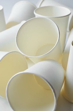 Çerçeve arka planında tek kullanımlık kağıt bardaklar yığını. İçecekler için ayrıştırılabilir materyalden yapılmış. Soğuk içecekler, kapaksız tek kullanımlık kaplar.