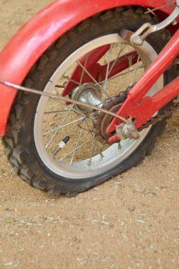 Tekerleğin patlak lastiğinin kabataslak kum çakıl yüzeyine yakın çekimi, motorun arka lastiği delinme ya da yırtılma nedeniyle hızlı bozulma, kopyalama alanı ile seçici odak