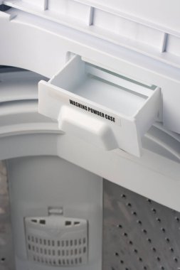 Çamaşır deterjanı dolabının beyaz renkli çamaşır makinesindeki yakın çekmecesi, fotokopi alanı olan yumuşak odak