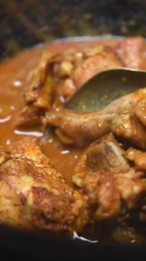 Baharatlı tavuk yemeği ya da soslu köri, lezzetli popüler mutfak, dikey yönelimde yumuşak odak, 60 fps 'de yavaş çekim.