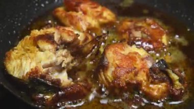 Hindistancevizi yağında kızartılmış balık parçaları, köpüren ve ışıldayan yağlı altın kahverengi balık, gerçek zamanlı olarak yumuşak odaklı.